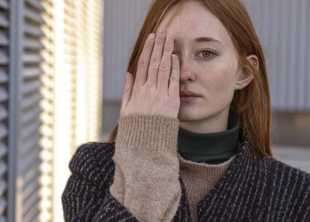 Woman covering one eye, highlighting visual awareness or concern