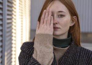 Woman covering one eye, highlighting visual awareness or concern